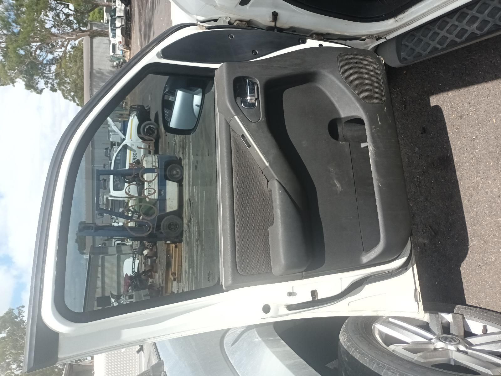 A White Car with the Door Open is Parked on the Side of the Road — South West 4WD Wreckers In Brisbane, QLD