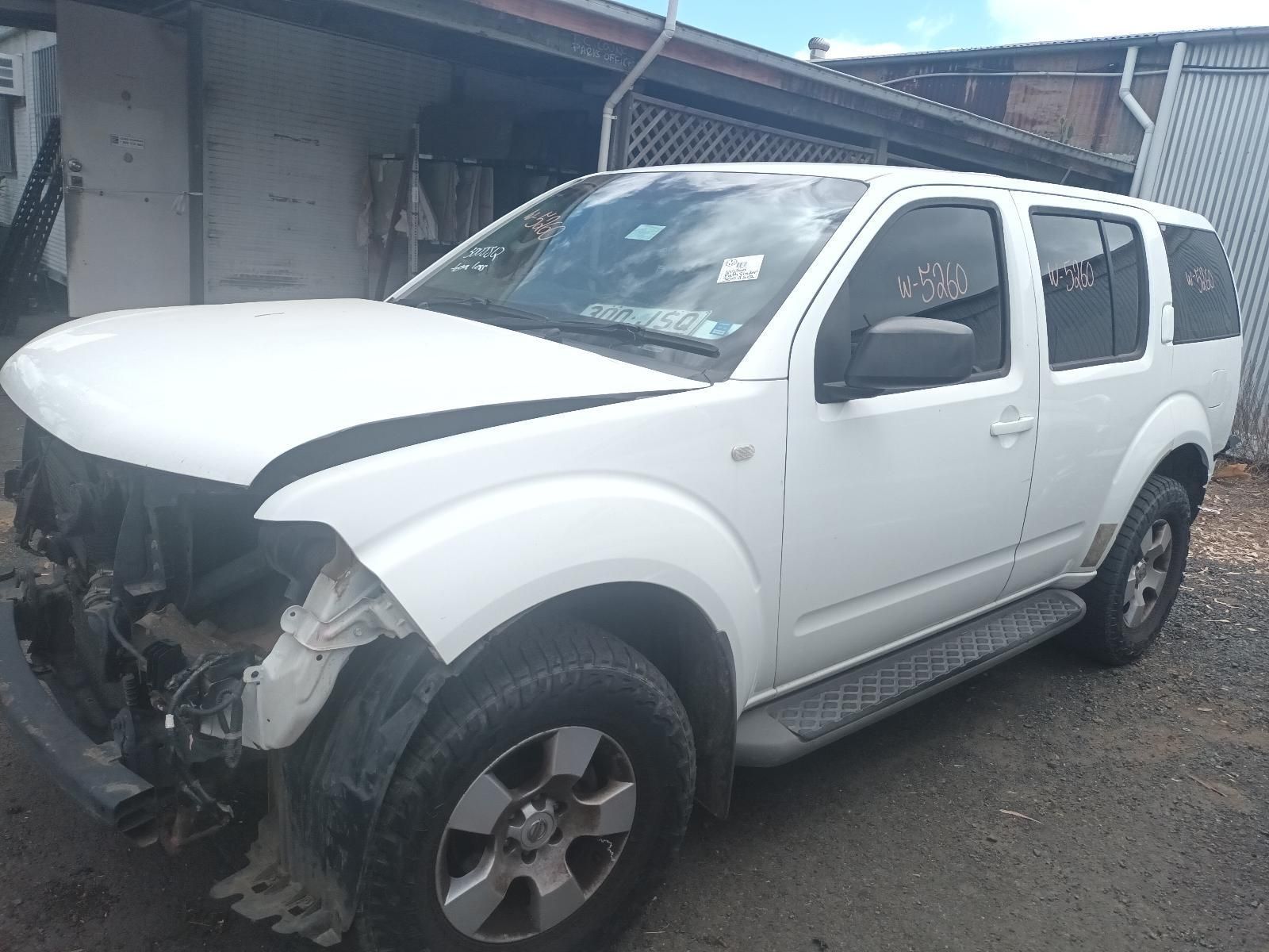 A White Nissan Pathfinder is Parked in Front of a Building — South West 4WD Wreckers In Brisbane, QLD