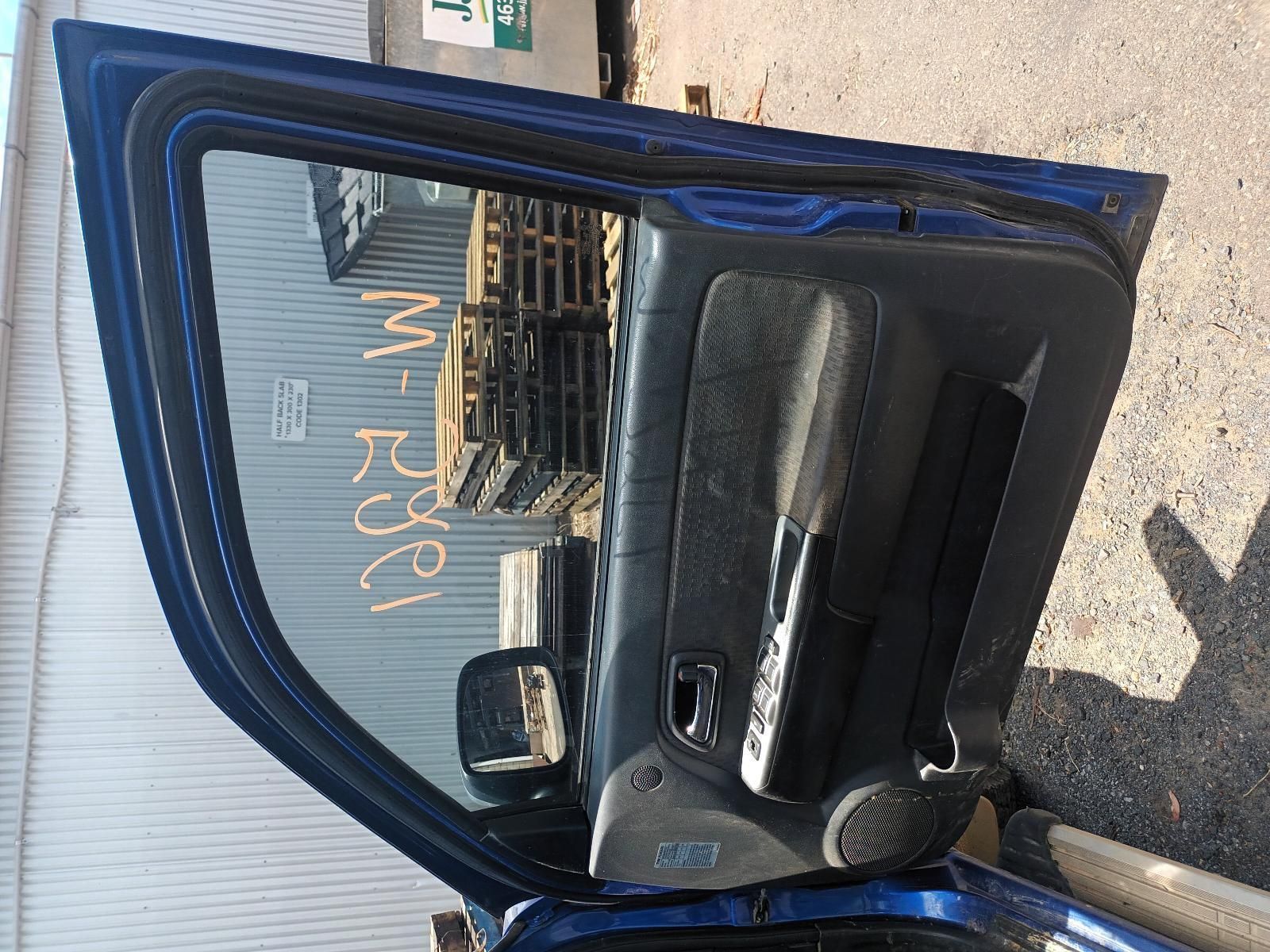 A Blue Car with the Door Open is Parked in Front of a Building — South West 4WD Wreckers In Brisbane, QLD