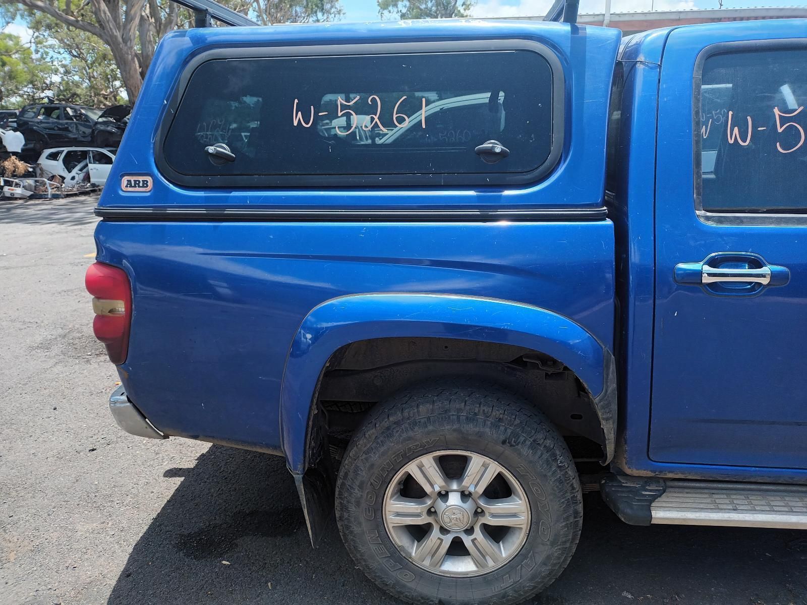 A Blue Truck with a Canopy on Top of It is Parked in a Parking Lot — South West 4WD Wreckers In Brisbane, QLD