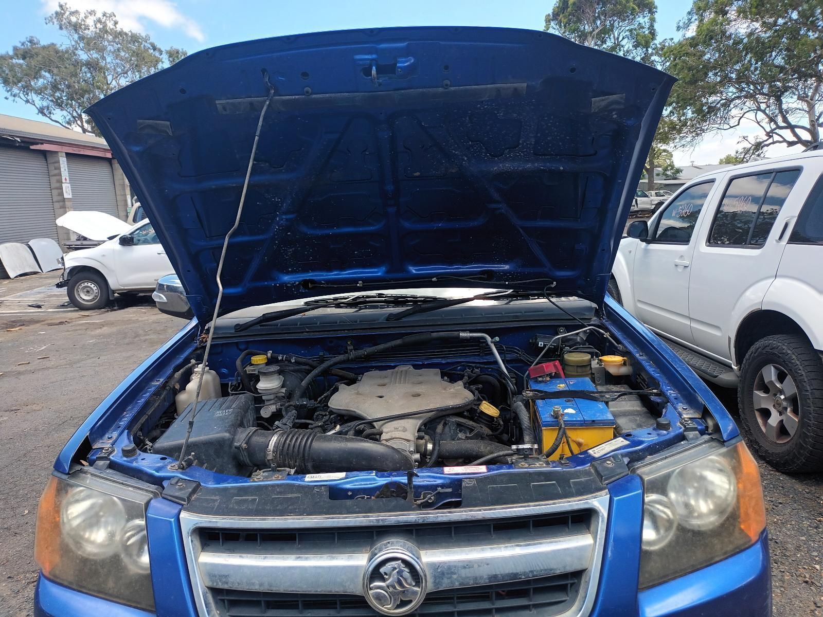 A Blue Car with the Hood Up is Parked in a Parking Lot — South West 4WD Wreckers In Brisbane, QLD