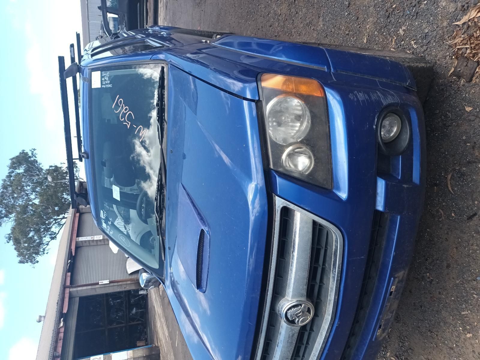 A Blue Car is Parked in Front of a Garage — South West 4WD Wreckers In Brisbane, QLD