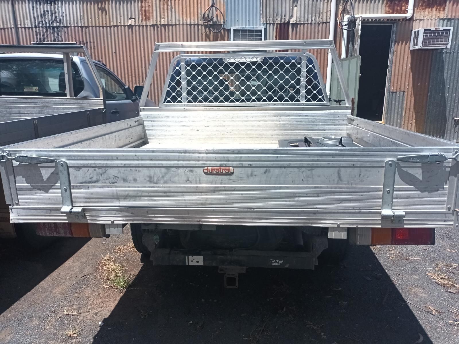 A Silver Truck is Parked in Front of a Building — South West 4WD Wreckers in Harristown, QLD