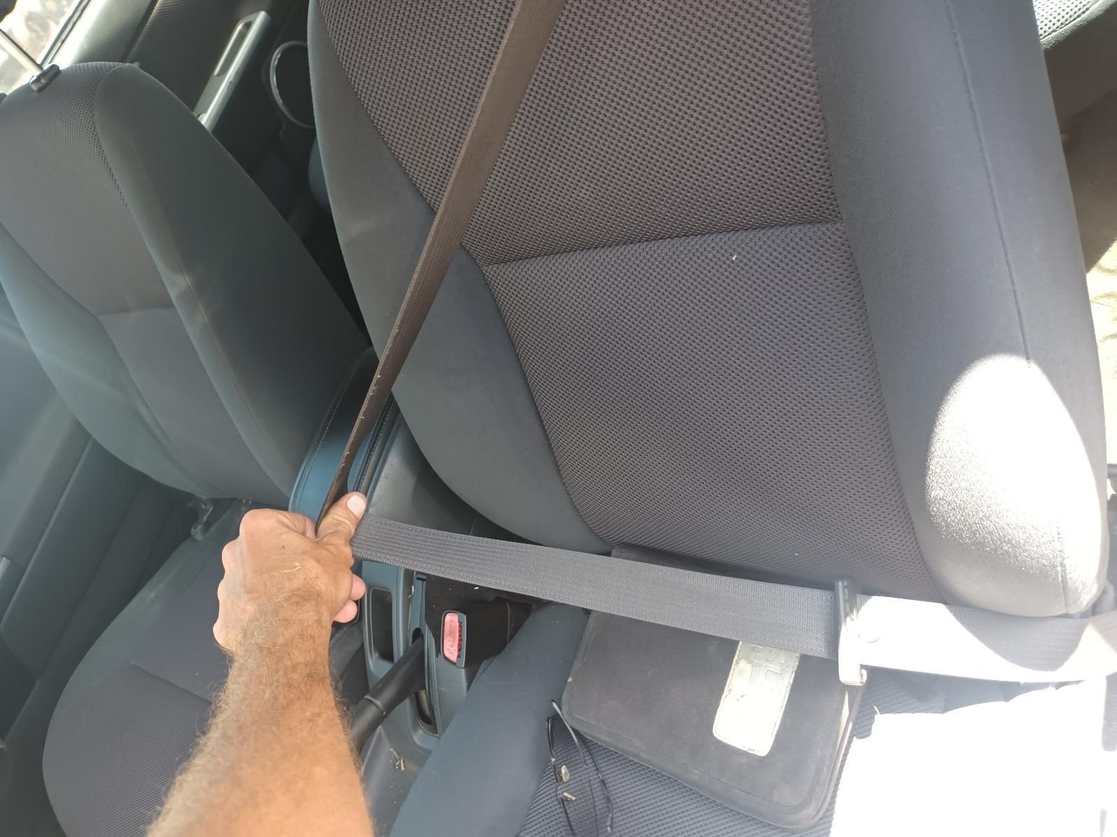 A Man is Putting on a Seat Belt in a Car — South West 4WD Wreckers in Harristown, QLD
