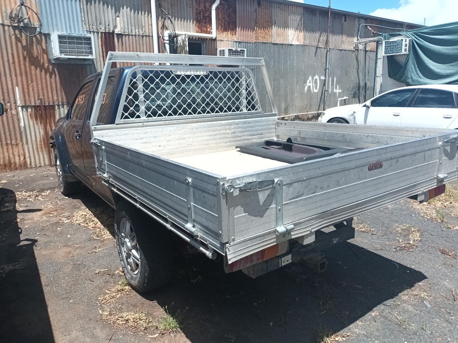 A Truck with a Tray on the Back is Parked in Front of a Building — South West 4WD Wreckers in Harristown, QLD