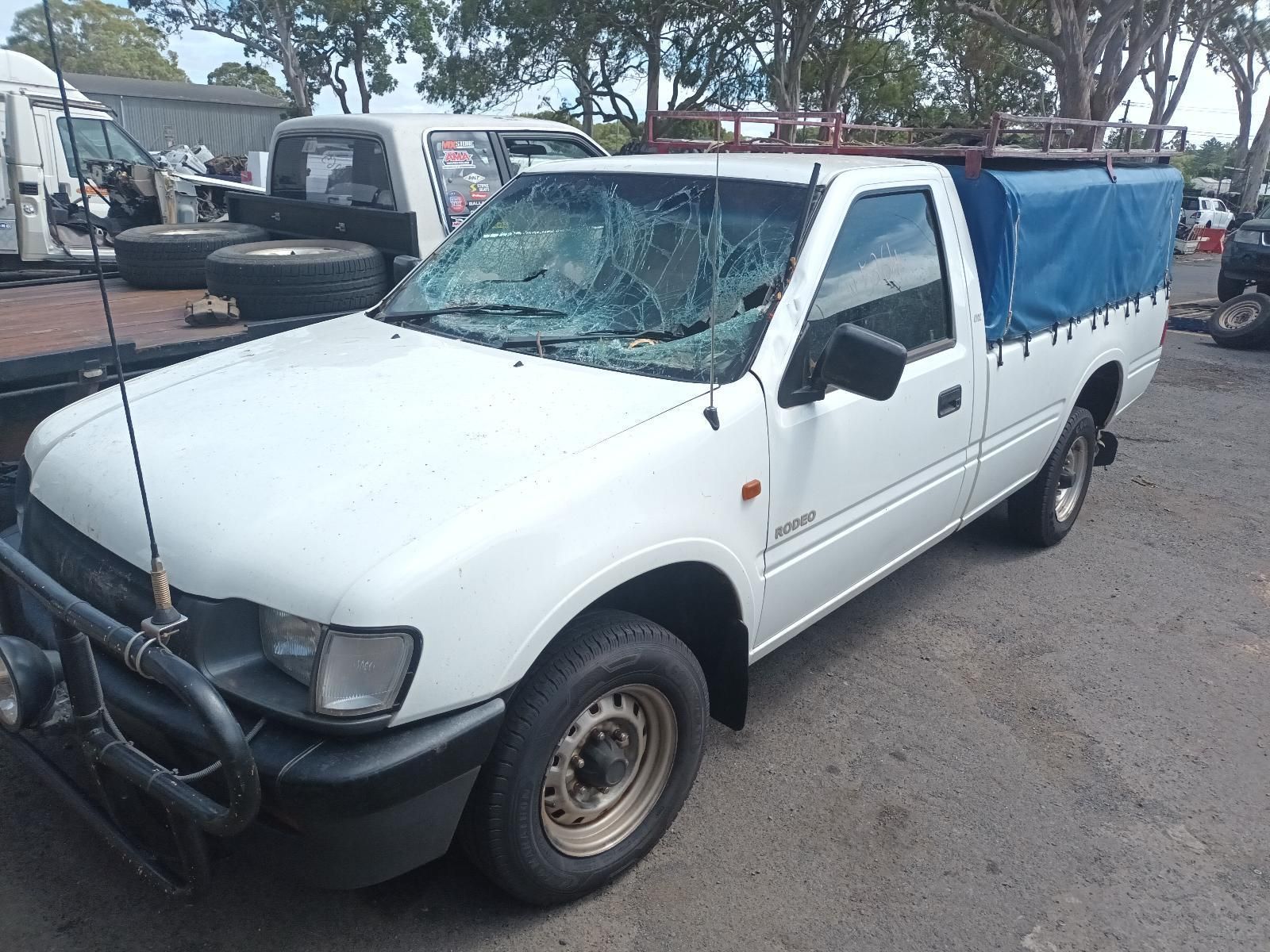 A White Truck with a Blue Tarp on the Back is Parked in a Parking Lot — South West 4WD Wreckers in Harristown, QLD