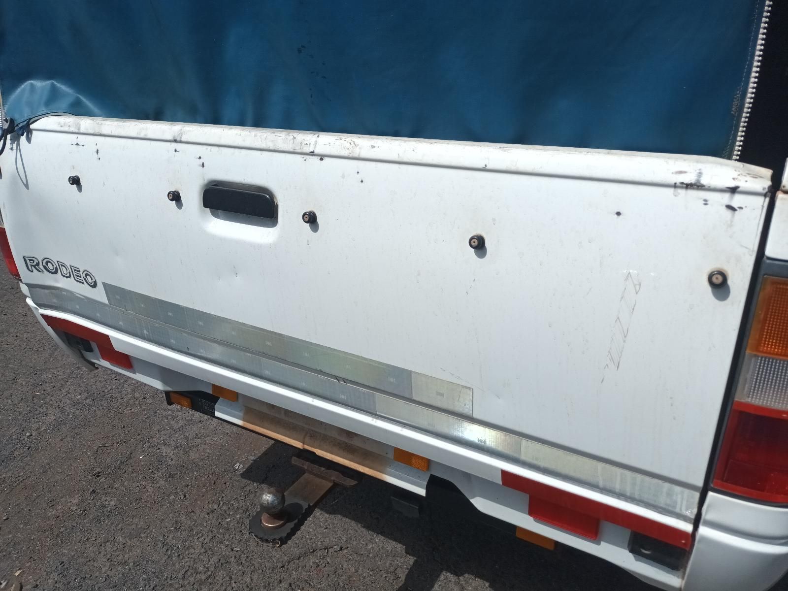 A White Truck with a Blue Tarp on the Back is Parked on the Side of the Road — South West 4WD Wreckers In Brisbane, QLD