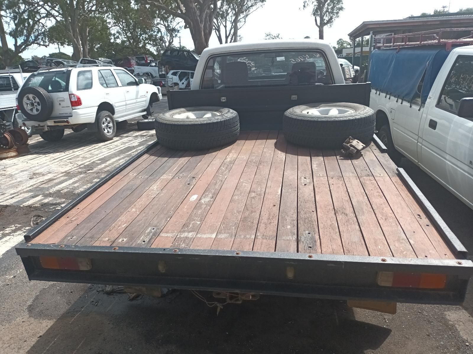 A Pickup Truck with a Wooden Bed is Parked in a Parking Lot — South West 4WD Wreckers In Brisbane, QLD