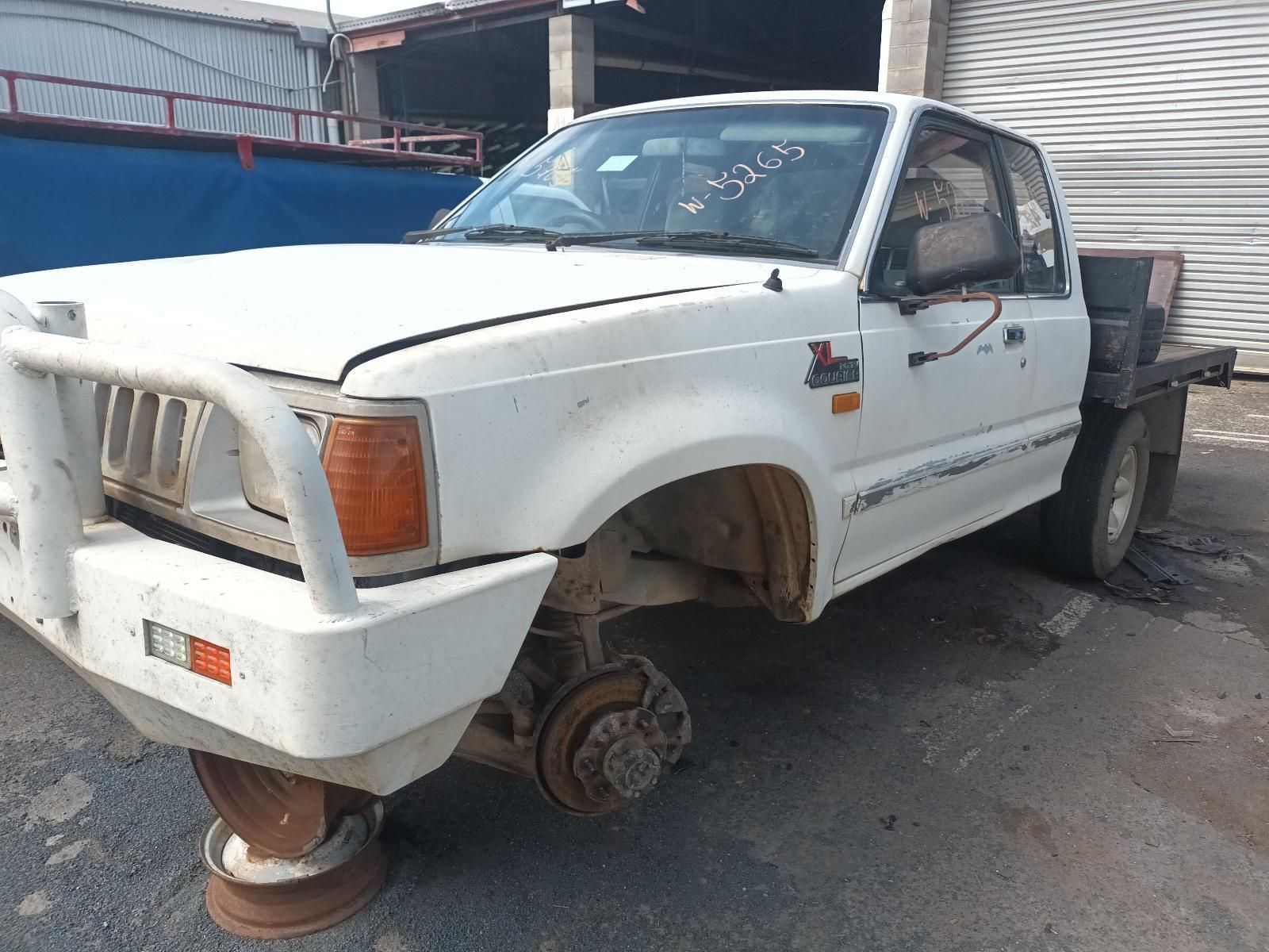A White Truck with a Broken Wheel is Parked on the Side of the Road — South West 4WD Wreckers In Brisbane, QLD