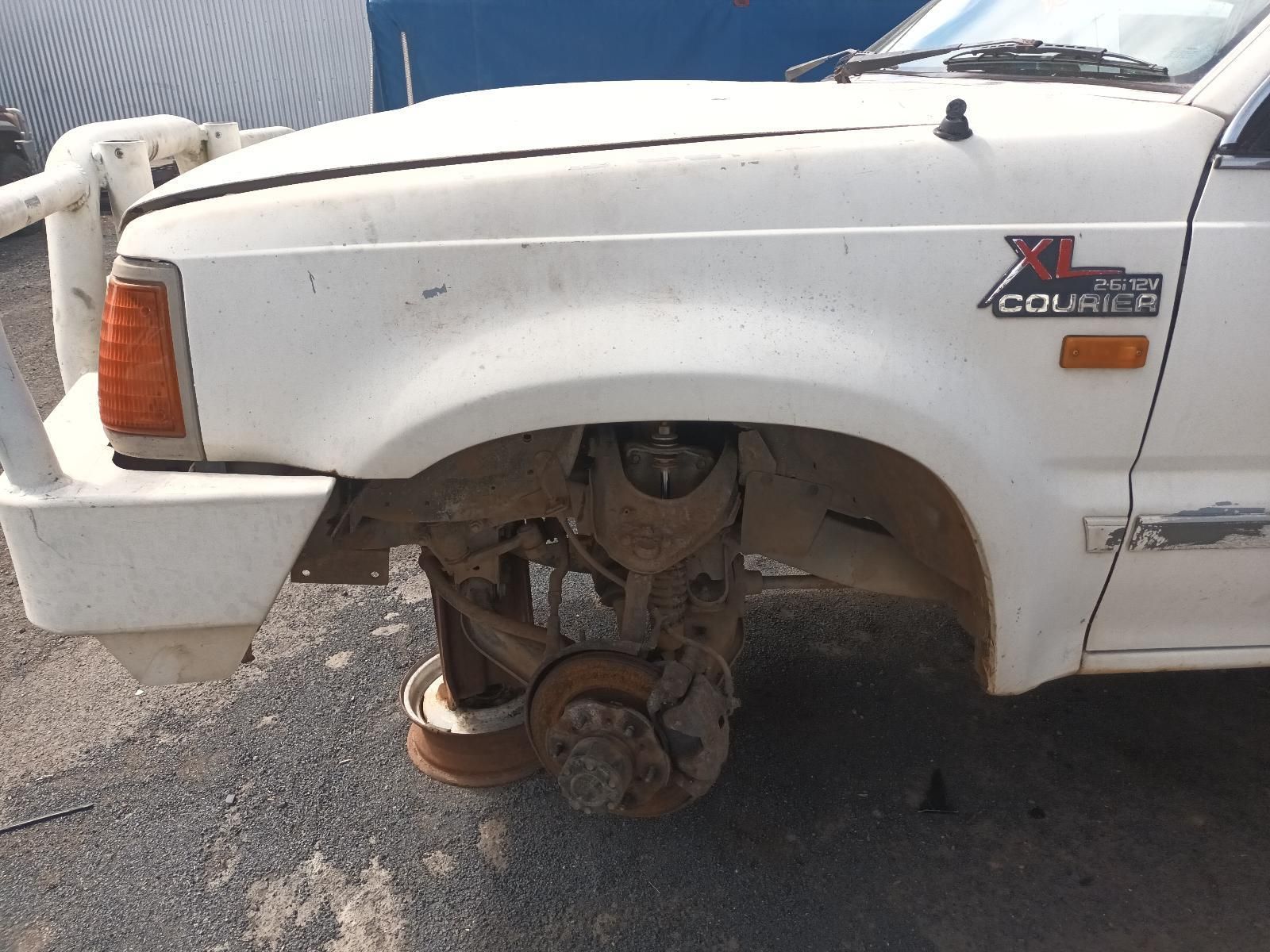 A White Truck with the Word Courier on the Fender — South West 4WD Wreckers In Brisbane, QLD