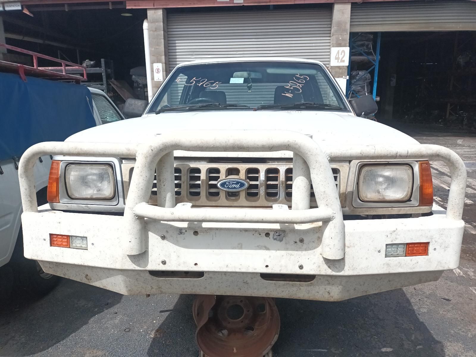 A White Ford Truck is Parked in Front of a Garage — South West 4WD Wreckers In Brisbane, QLD