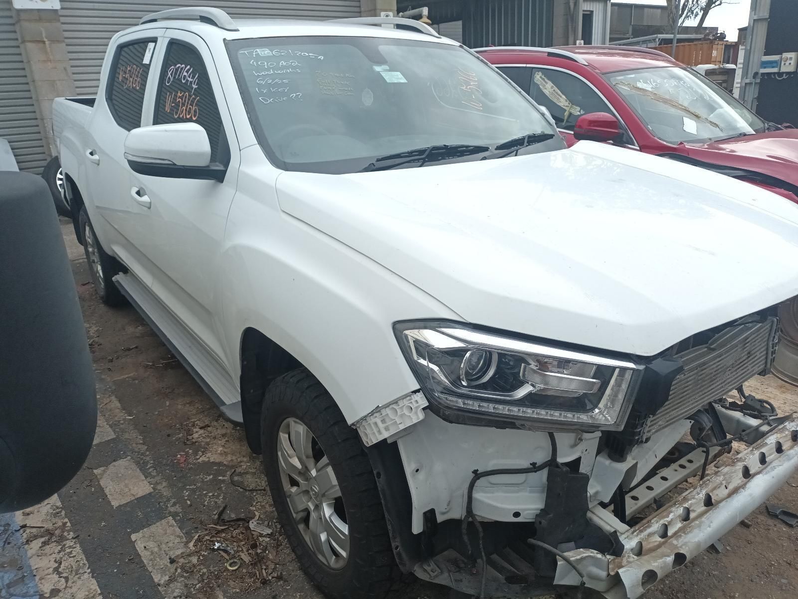 A White Truck with a Damaged Front End is Parked Next to a Red Truck — South West 4WD Wreckers In Brisbane, QLD
