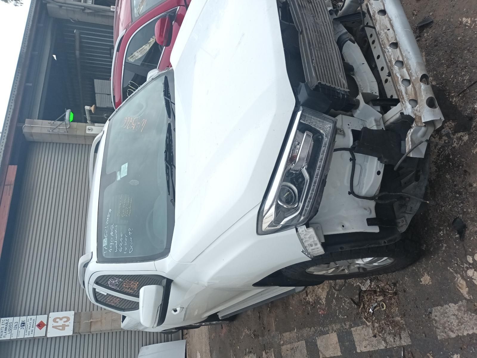 A White Car with a Damaged Front End is Parked in Front of a Building — South West 4WD Wreckers In Brisbane, QLD