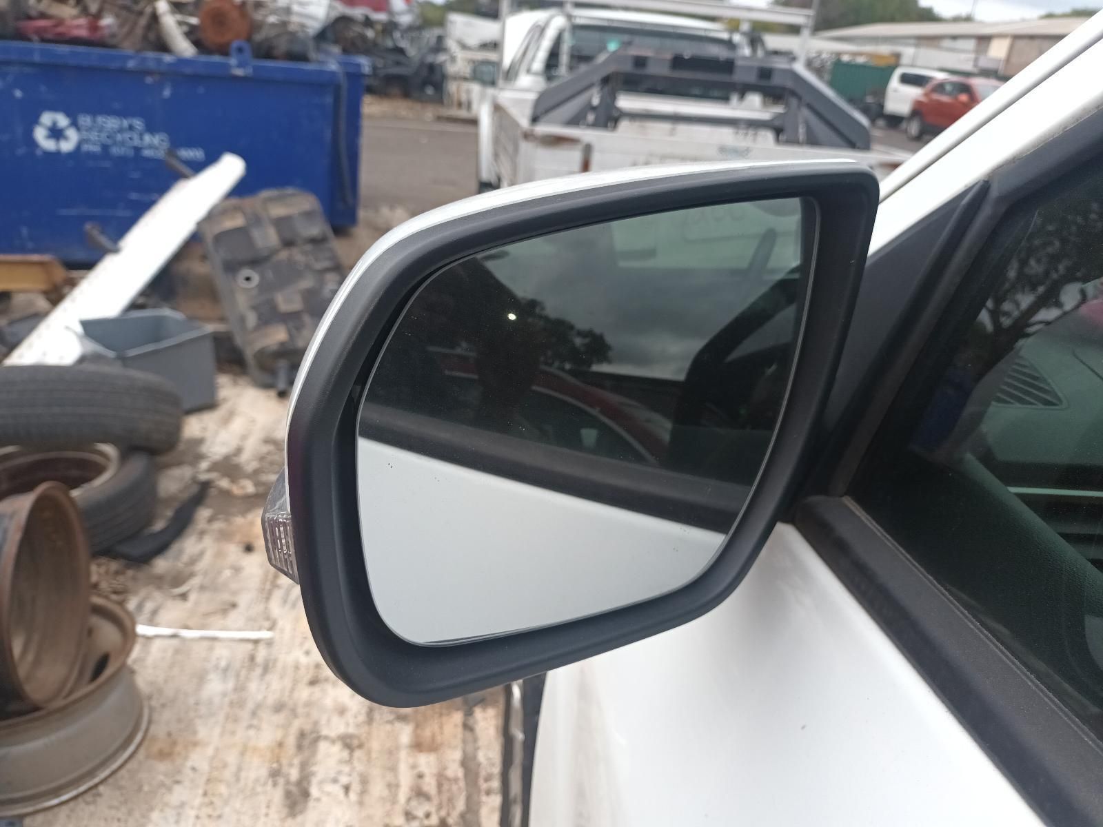 A Side View Mirror on a White Car with a Blue Dumpster in the Background — South West 4WD Wreckers In Brisbane, QLD