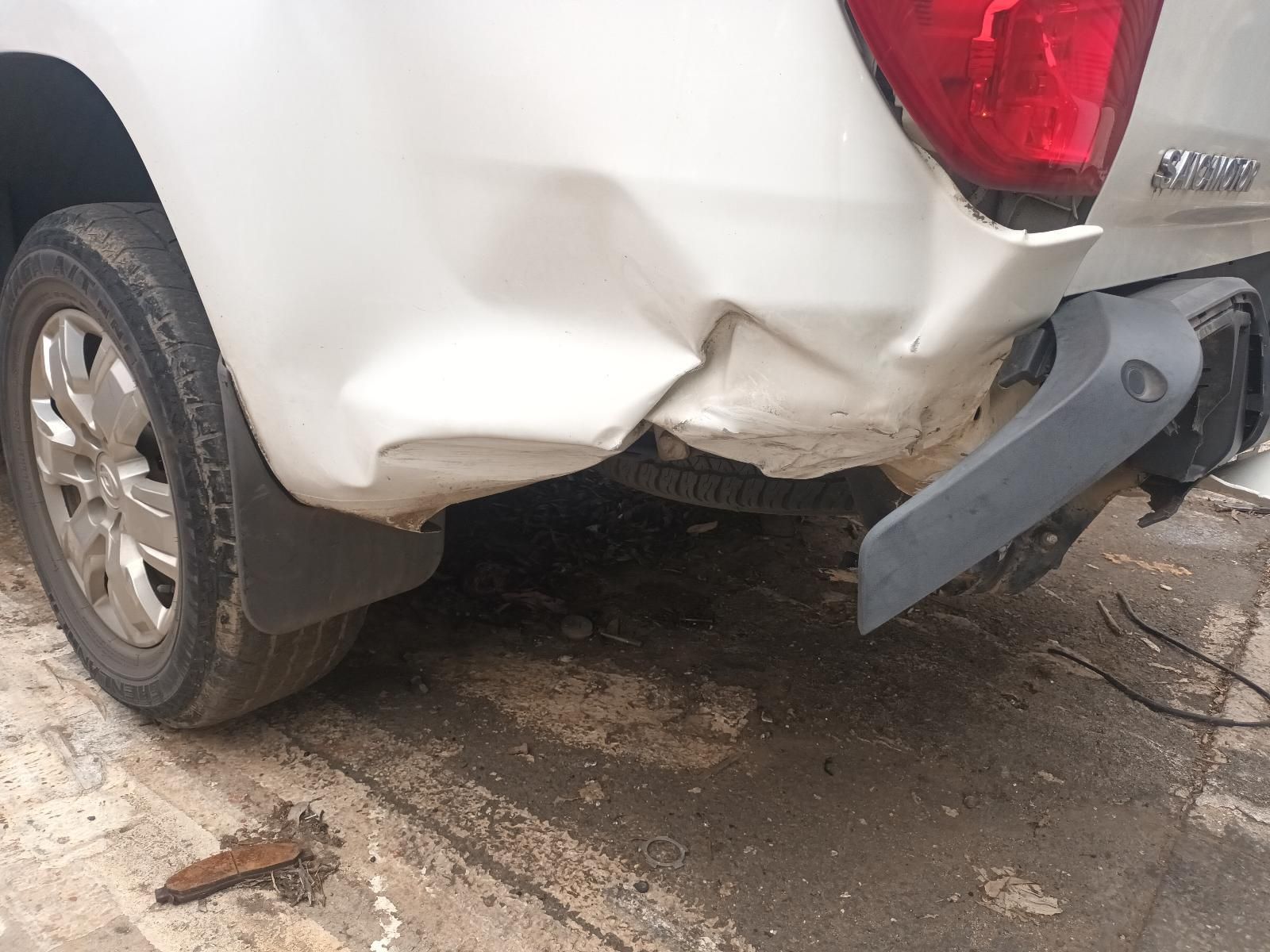 A White Truck with a Damaged Bumper is Parked on the Side of the Road — South West 4WD Wreckers In Brisbane, QLD