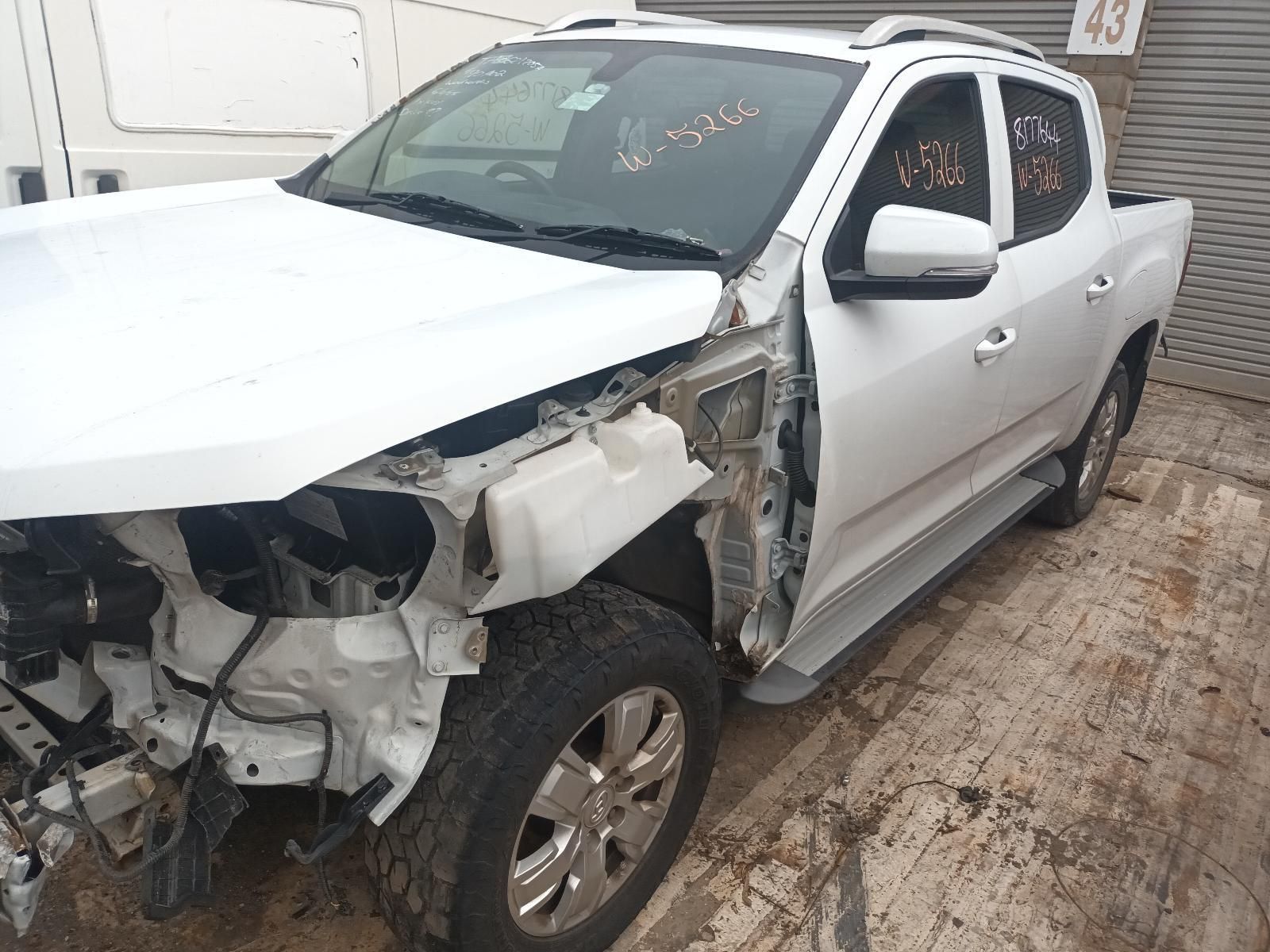 A White Truck That Has Been Damaged is Parked in Front of a Building — South West 4WD Wreckers In Brisbane, QLD