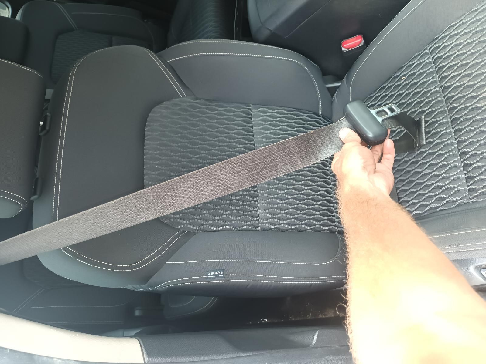 A Person is Putting on a Seat Belt in a Car — South West 4WD Wreckers In Brisbane, QLD