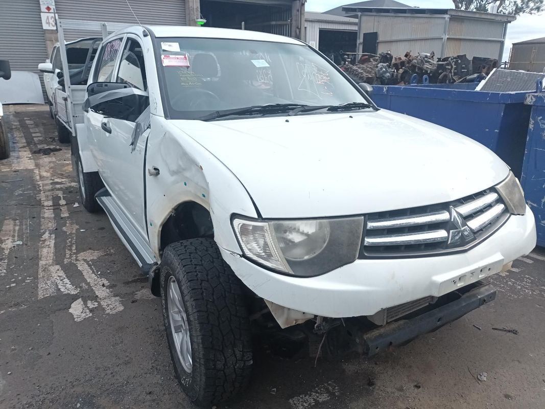 A White Mitsubishi Triton is Sitting on the Side of the Road — South West 4WD Wreckers In Brisbane, QLD