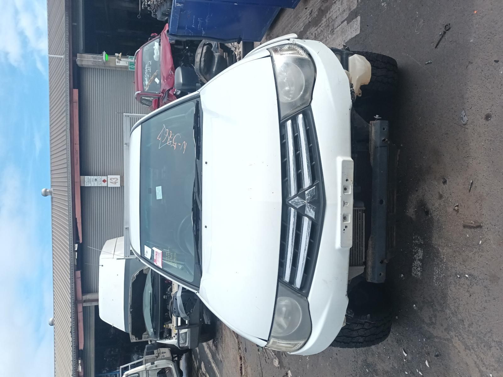 A White Mitsubishi Triton Truck is Sitting in a Junkyard — South West 4WD Wreckers In Brisbane, QLD