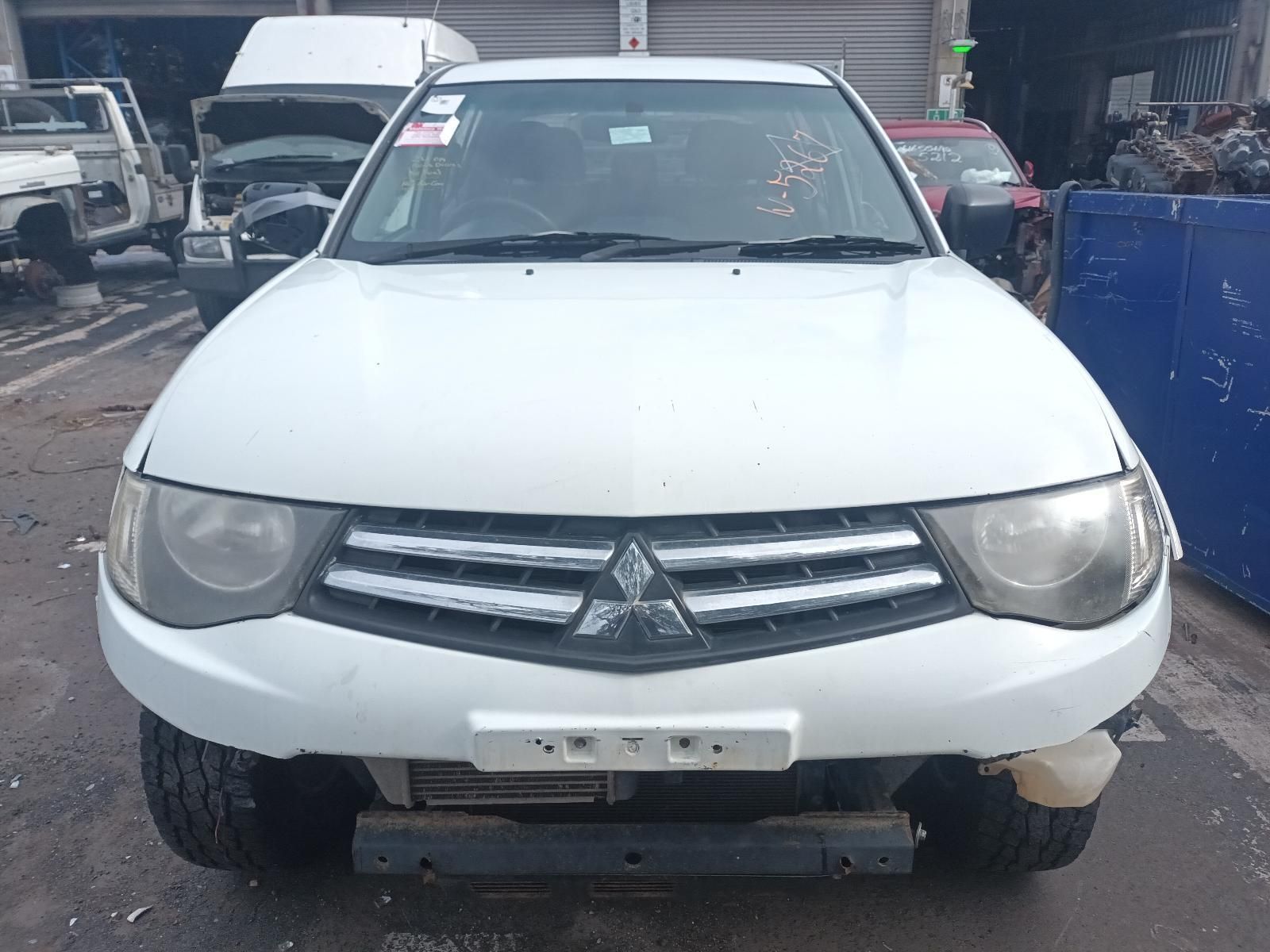 A White Mitsubishi Truck is Sitting in a Parking Lot — South West 4WD Wreckers In Brisbane, QLD