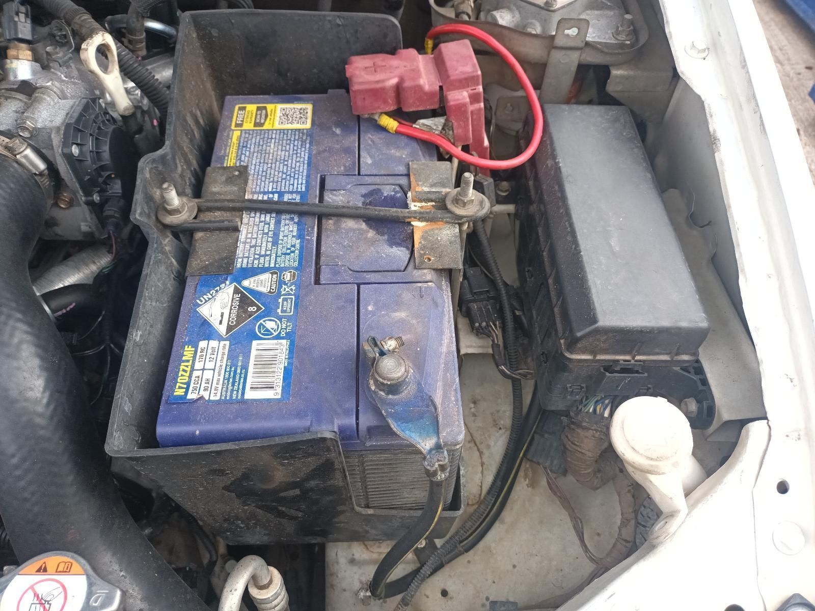 A Blue Battery is Sitting Under the Hood of a Car — South West 4WD Wreckers In Brisbane, QLD