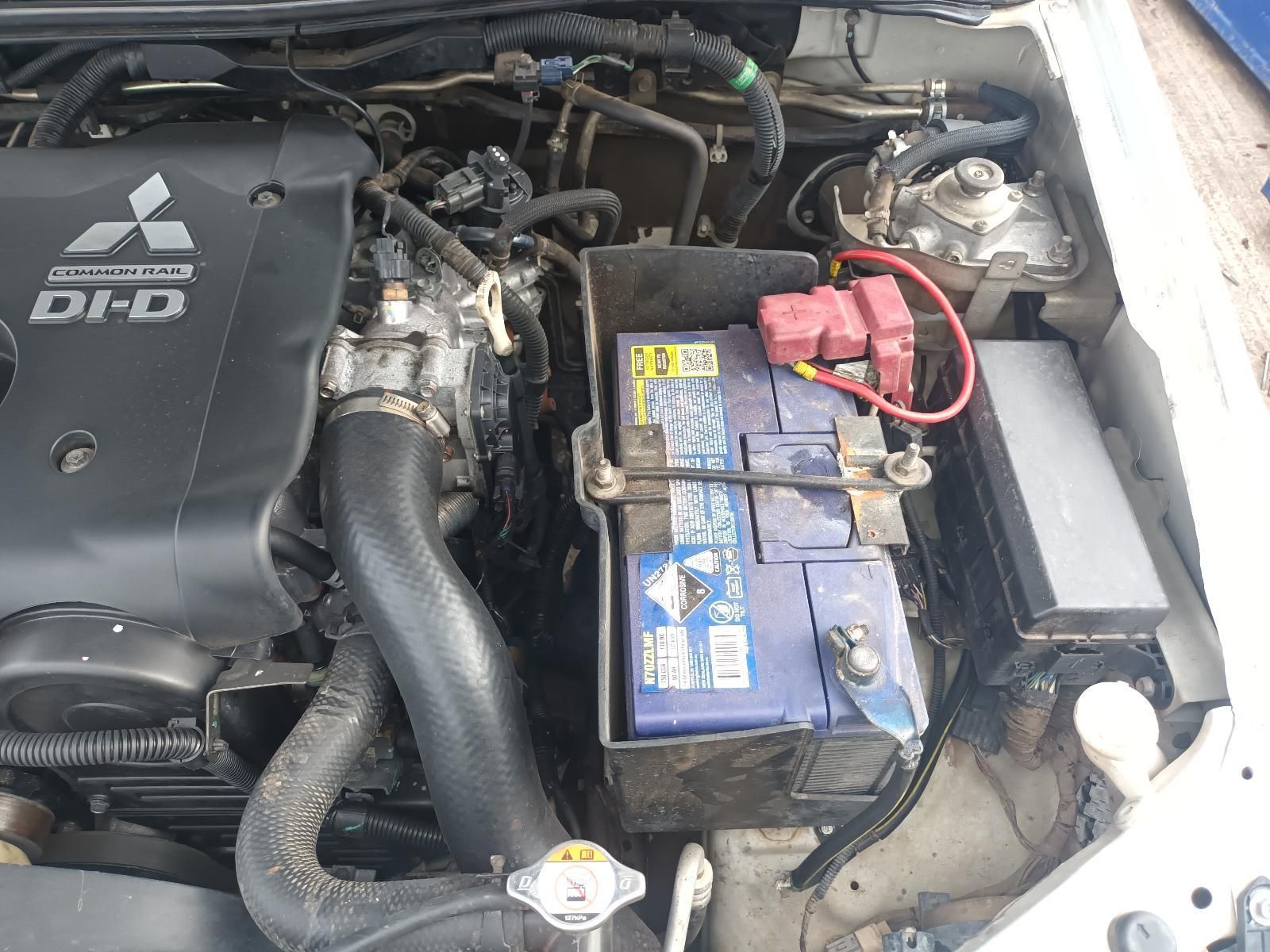 The Engine of a Mitsubishi Car with a Blue Battery — South West 4WD Wreckers In Brisbane, QLD