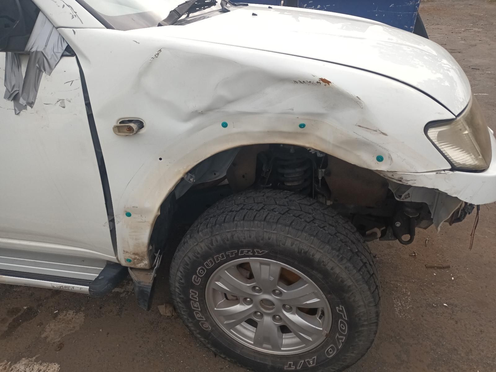 A White Truck with a Damaged Fender is Parked on the Side of the Road — South West 4WD Wreckers In Brisbane, QLD