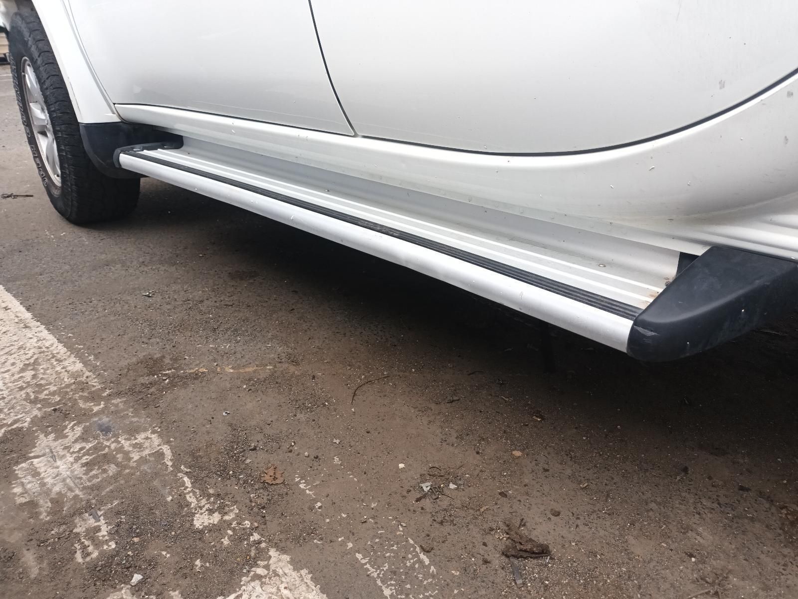 A White Car with Side Steps is Parked on the Side of the Road — South West 4WD Wreckers In Brisbane, QLD