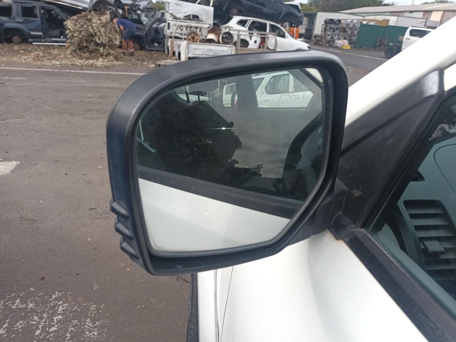 A Side View Mirror on a White Car in a Parking Lot — South West 4WD Wreckers In Brisbane, QLD