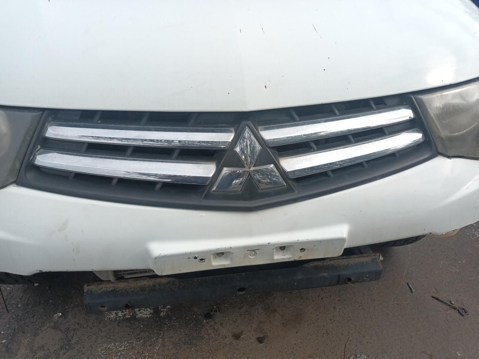 A White Mitsubishi Car is Parked on the Side of the Road — South West 4WD Wreckers In Brisbane, QLD