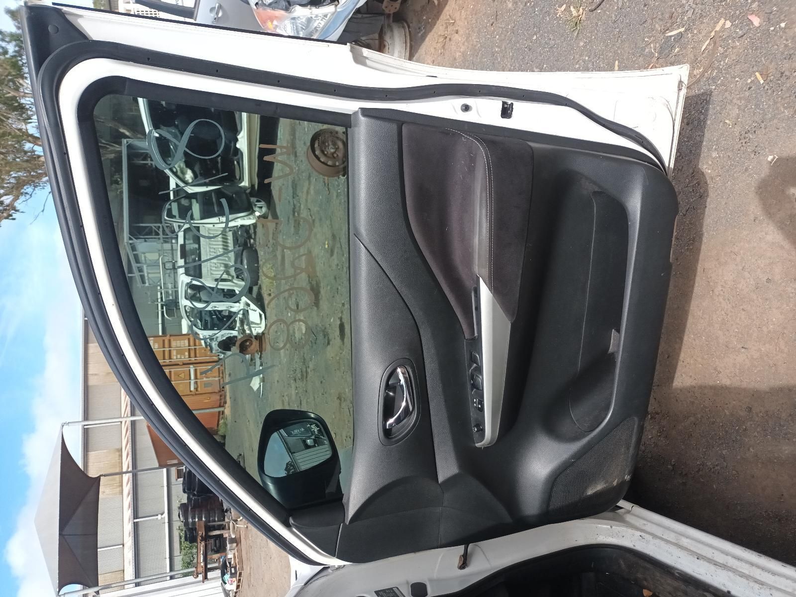 A White Car with the Door Open is Parked on the Side of the Road — South West 4WD Wreckers In Brisbane, QLD