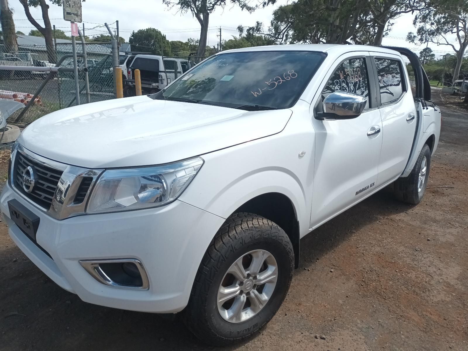 A White Nissan Pickup Truck is Parked in a Dirt Lot — South West 4WD Wreckers In Brisbane, QLD