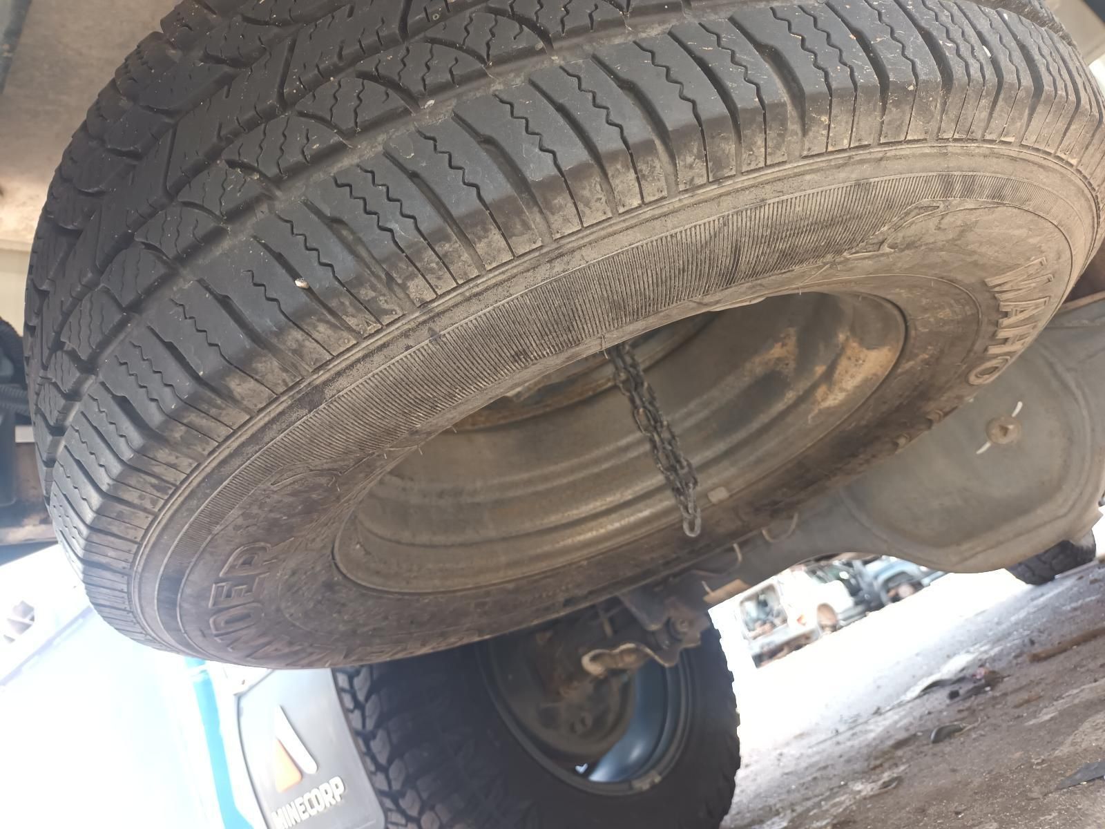 A Tire is Chained to the Back of a Car — South West 4WD Wreckers In Brisbane, QLD