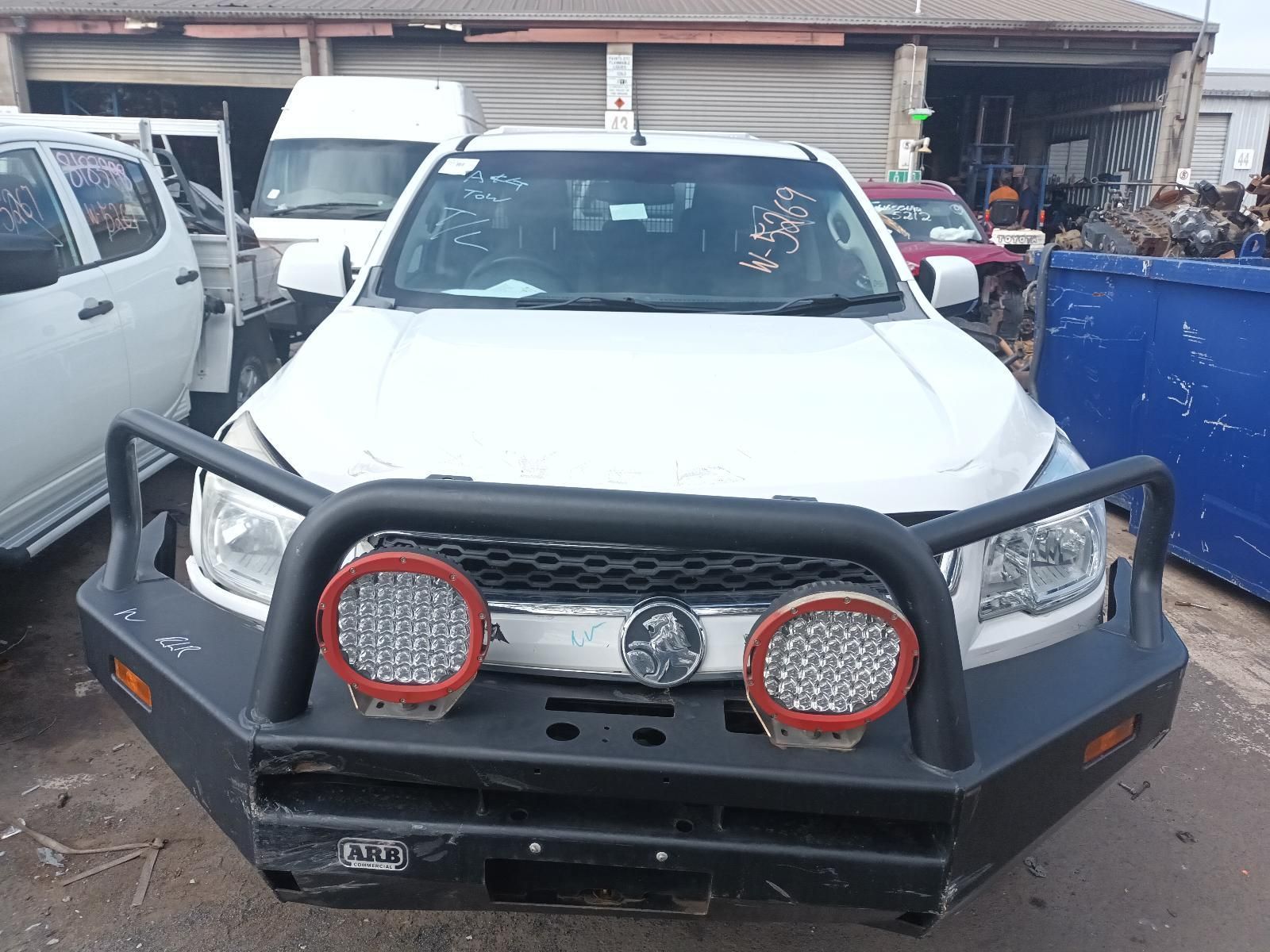 A White Truck with a Black Bumper is Parked in Front of a Building — South West 4WD Wreckers In Brisbane, QLD