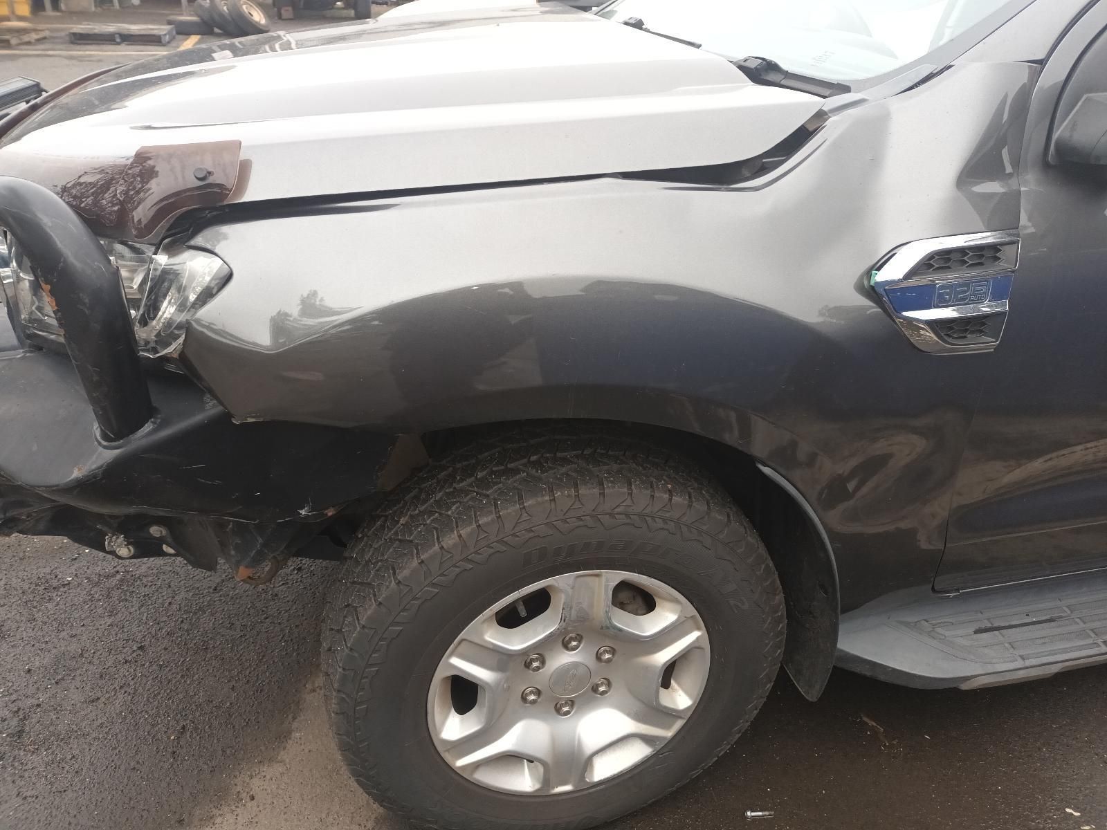 A Black Truck with a Damaged Hood is Parked on the Side of the Road — South West 4WD Wreckers In Brisbane, QLD
