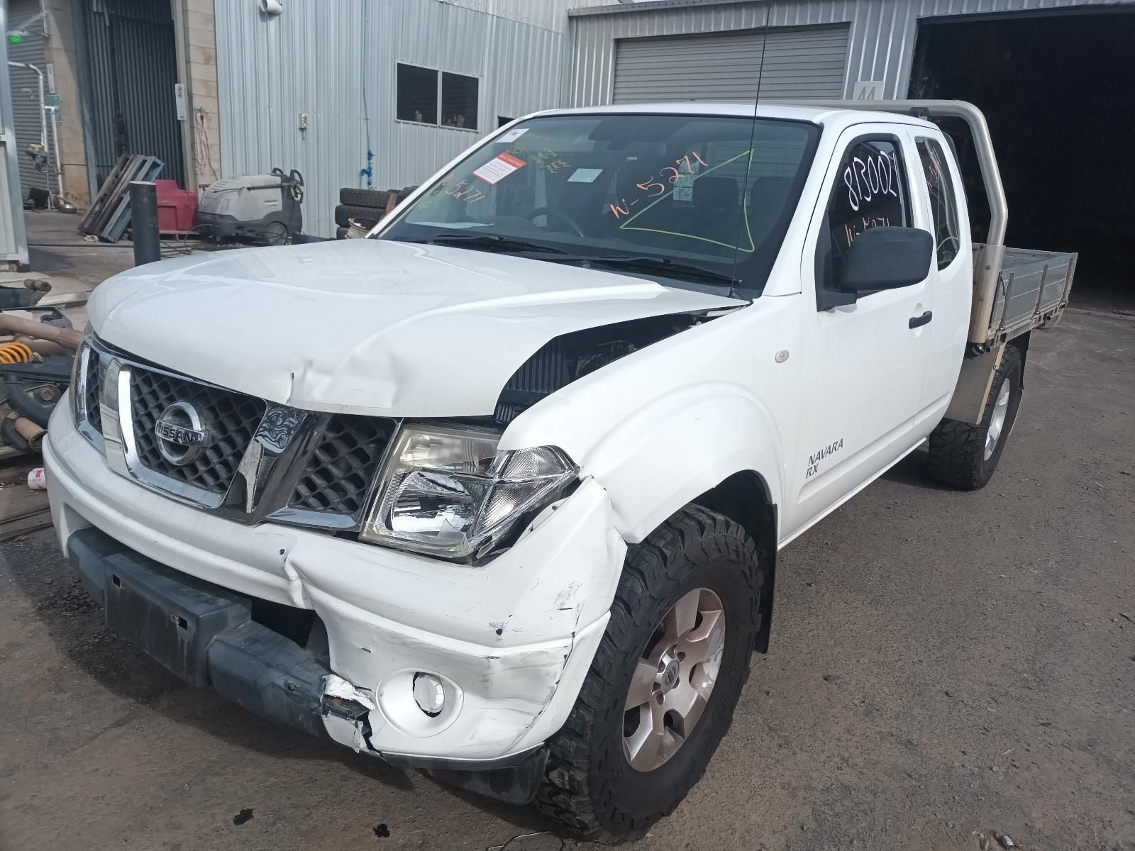 A White Truck with a Damaged Hood is Parked in Front of a Garage — South West 4WD Wreckers In Brisbane, QLD