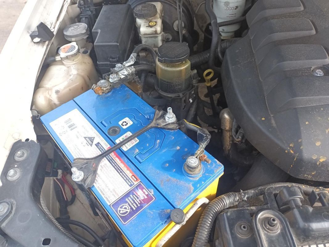 A Blue and Yellow Battery is Sitting Under the Hood of a Car — South West 4WD Wreckers In Brisbane, QLD