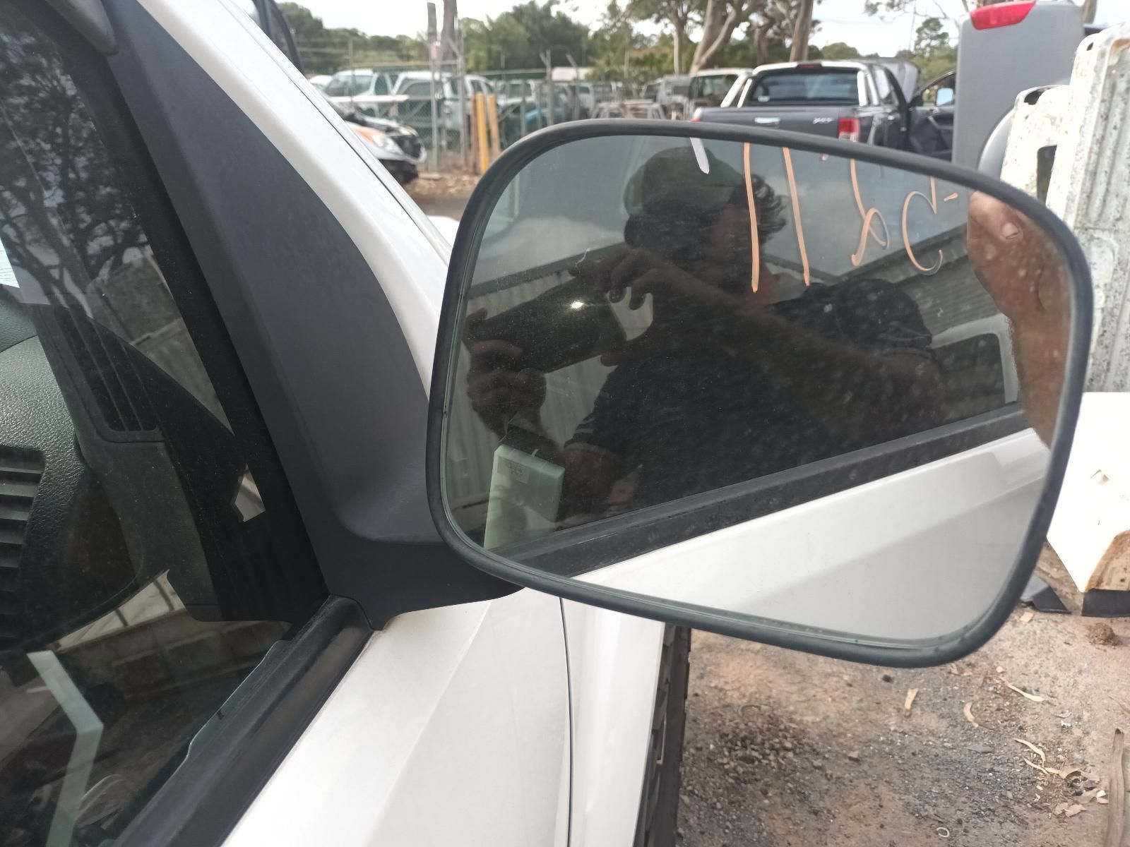 A Side View Mirror on a White Car Shows a Man Taking a Picture of Himself — South West 4WD Wreckers In Brisbane, QLD