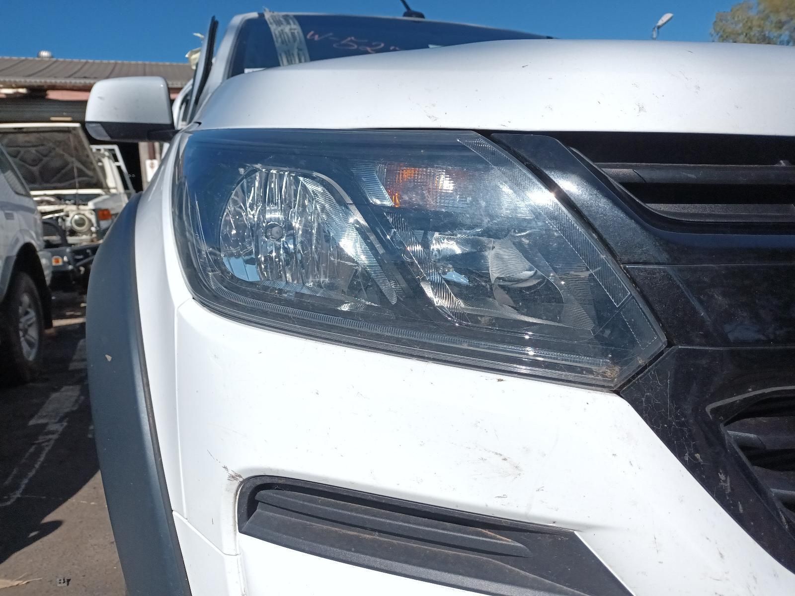 A Close Up of a White Car's Headlight in a Parking Lot — South West 4WD Wreckers in Harristown, QLD