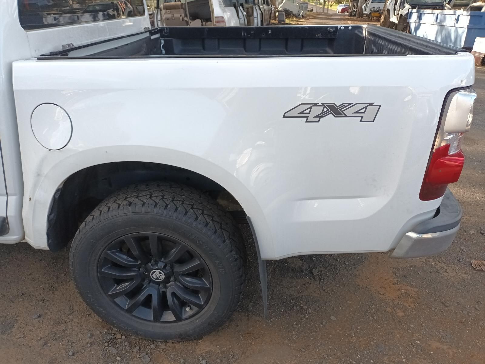 A White Pickup Truck With Black Wheels is Parked on a Dirt Road — South West 4WD Wreckers In Harristown, QLD