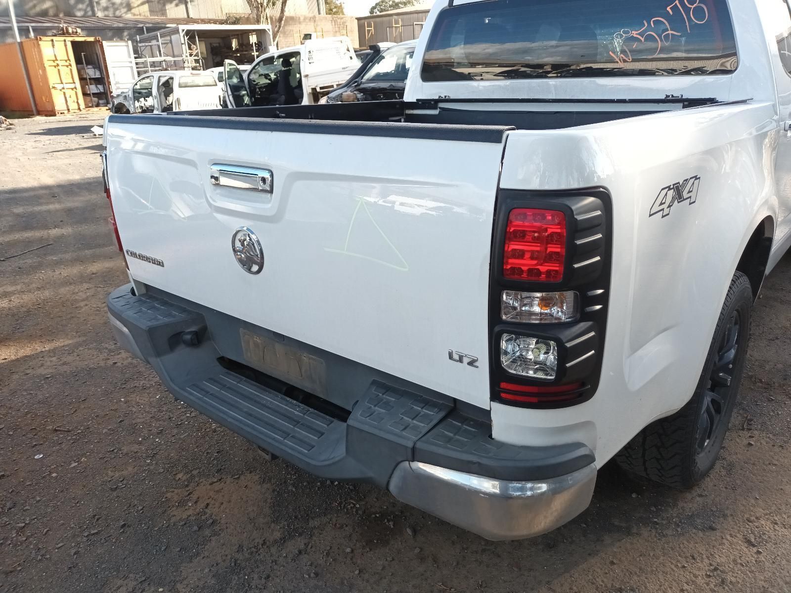 A White Pickup Truck With a Black Tail Light is Parked in a Parking Lot — South West 4WD Wreckers In Harristown, QLD