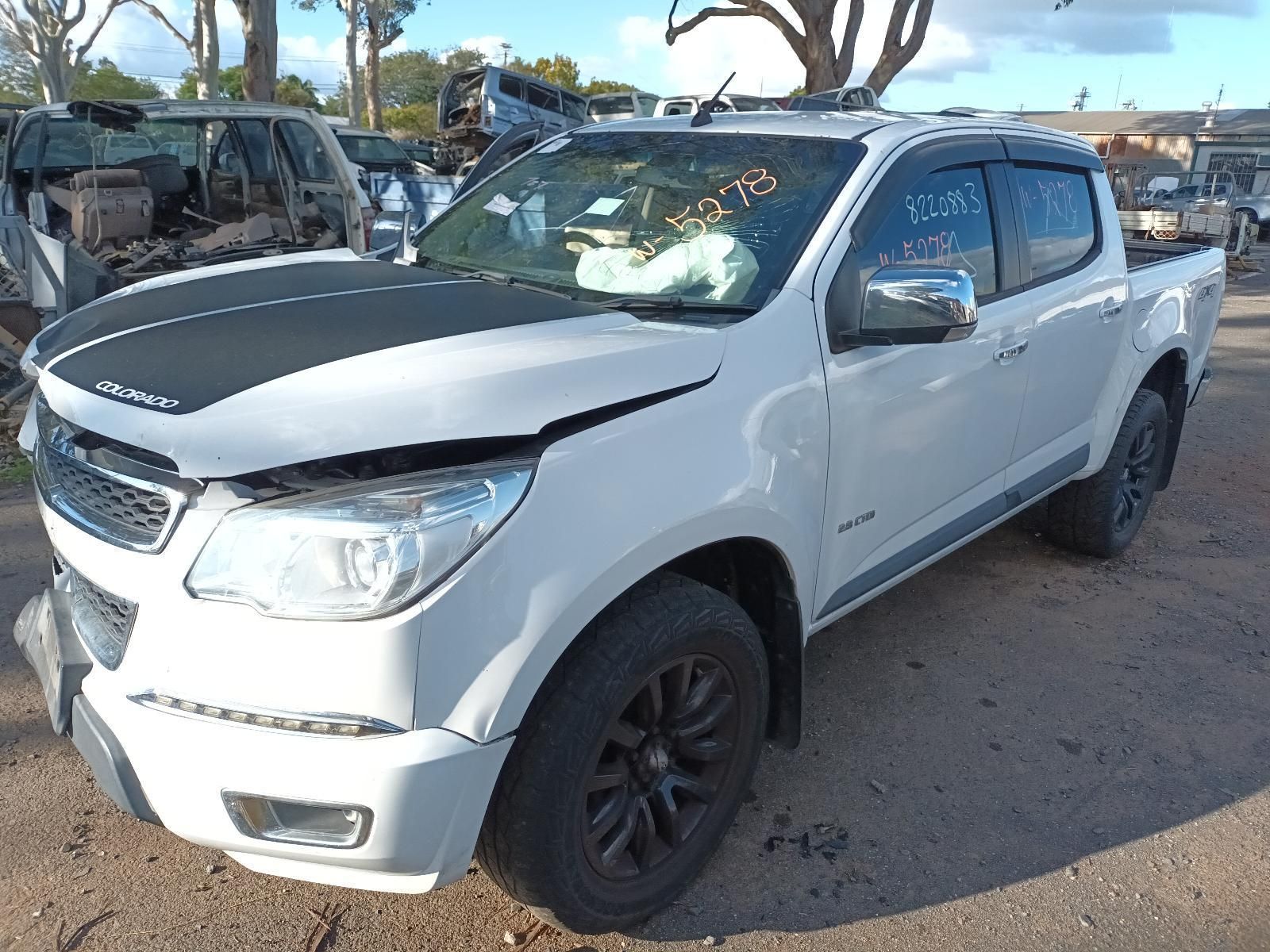 A White Truck With a Black Hood is Parked on the Side of the Road — South West 4WD Wreckers In Harristown, QLD