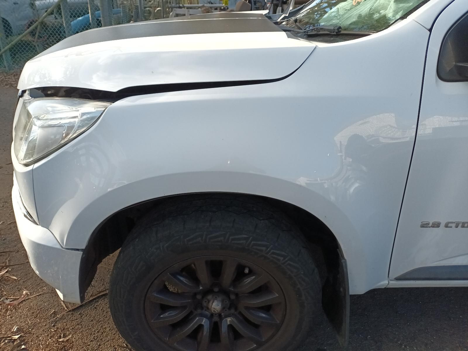 A White Truck With a Damaged Hood is Parked on the Side of the Road — South West 4WD Wreckers In Harristown, QLD