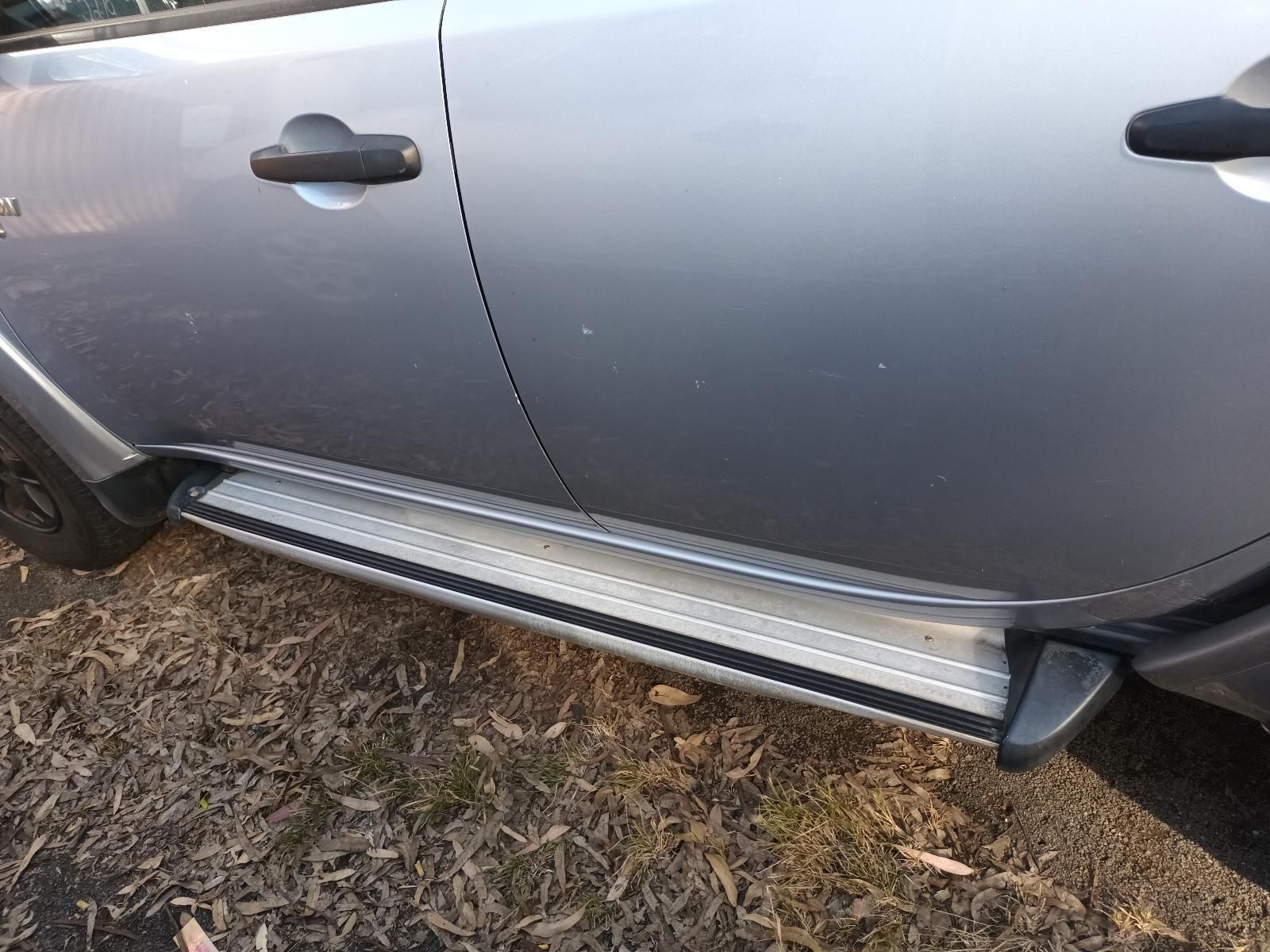 A Silver Car with a Side Step is Parked in the Grass — South West 4WD Wreckers in Harristown, QLD