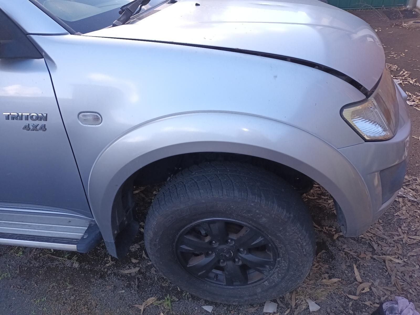A Silver Truck with a Black Tire is Parked on the Side of the Road — South West 4WD Wreckers in Harristown, QLD