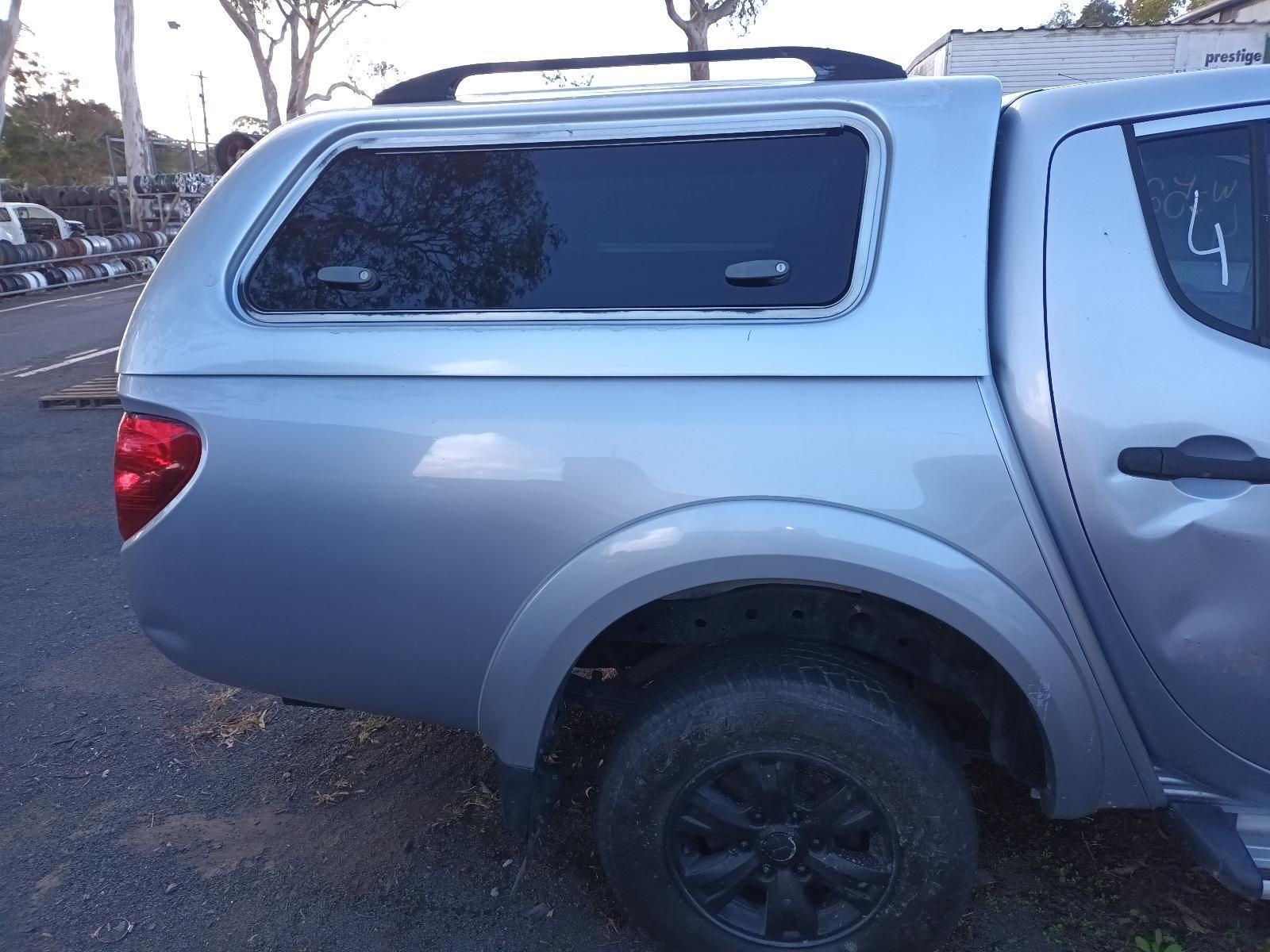 A Silver Truck with a Canopy on the Back is Parked on the Side of the Road — South West 4WD Wreckers in Harristown, QLD