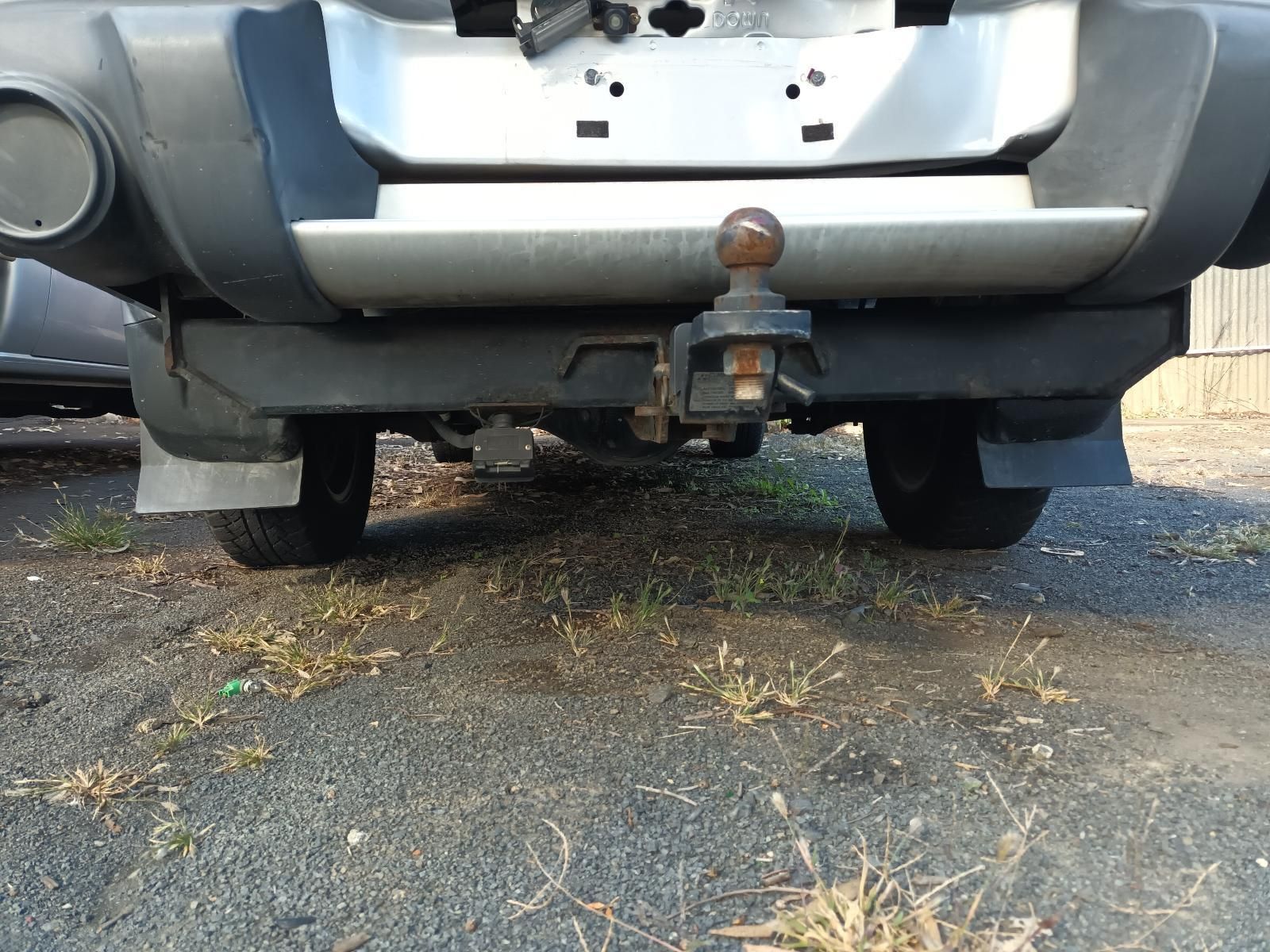 A Car with a Trailer Attached to It is Parked on the Side of the Road — South West 4WD Wreckers in Harristown, QLD