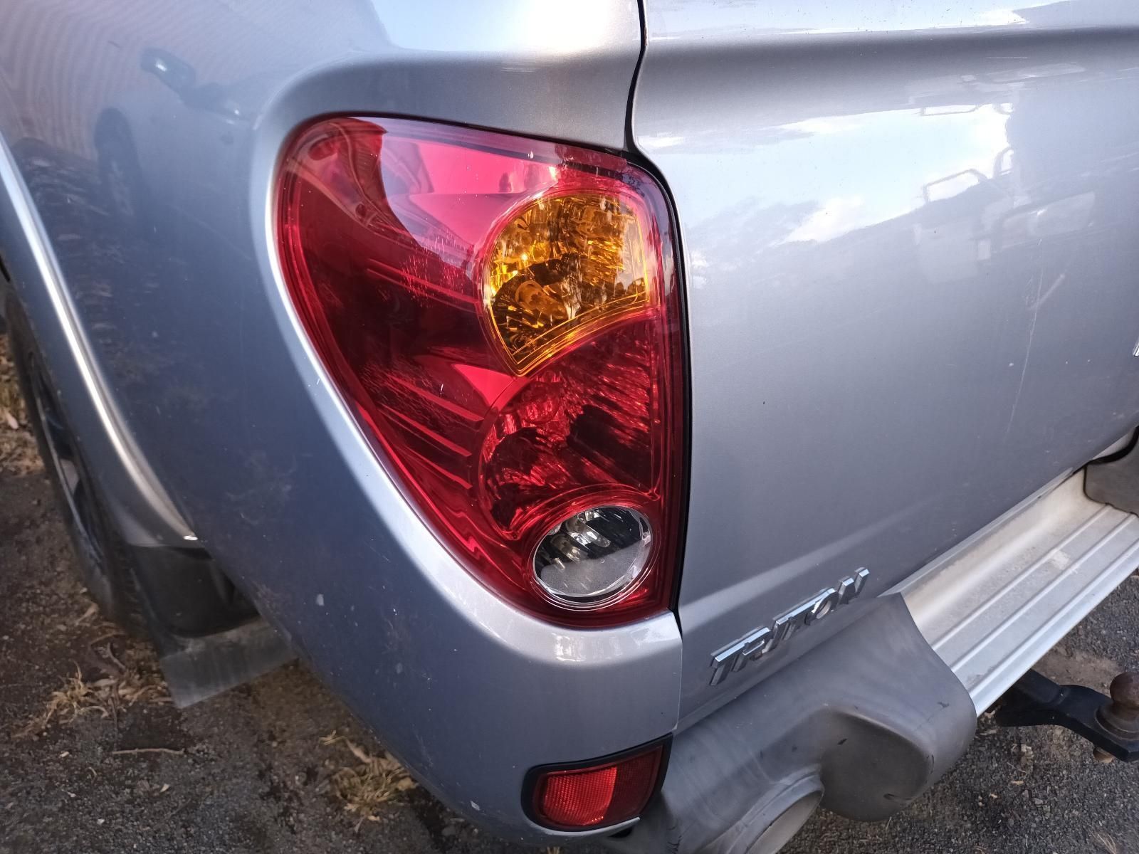 A Silver Truck with a Red Tail Light is Parked on the Side of the Road — South West 4WD Wreckers in Harristown, QLD