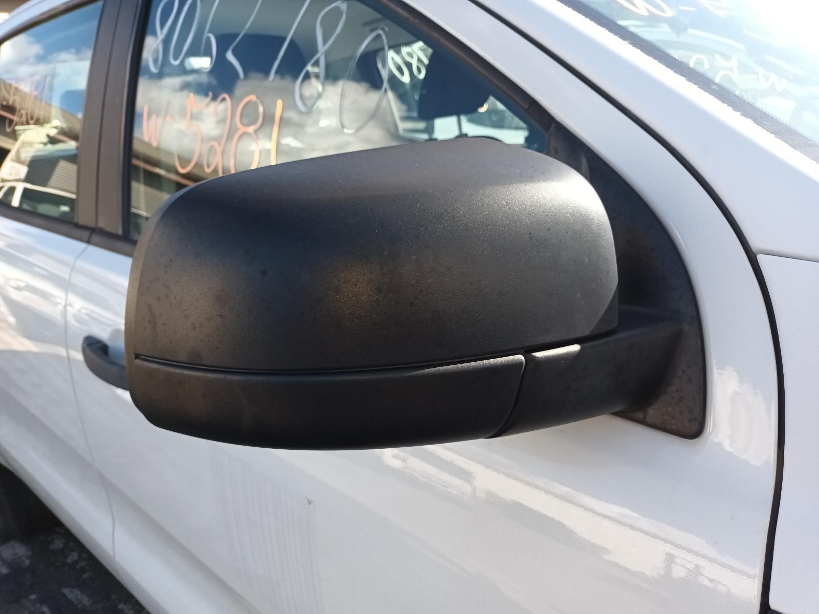A close up of a side view mirror on a white car