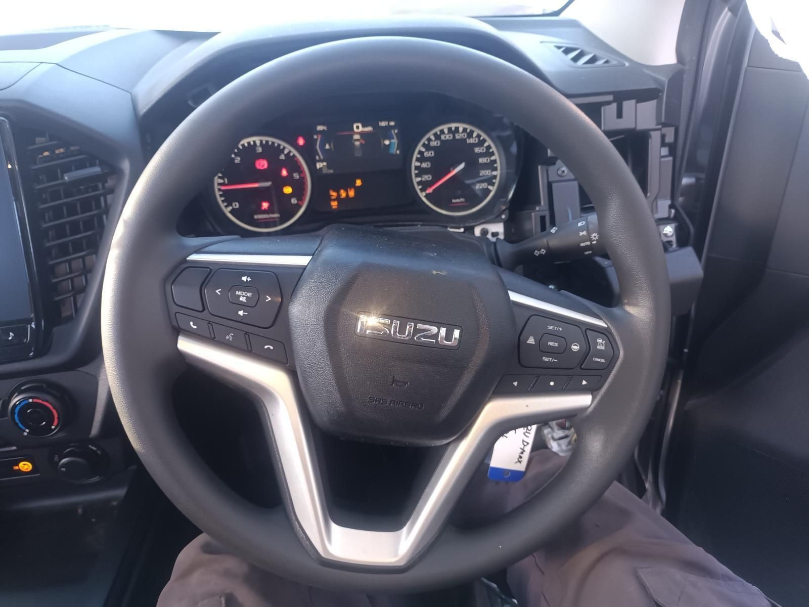 A Person is Sitting in a Car with a Steering Wheel That Says Isuzu on It — South West 4WD Wreckers in Harristown, QLD